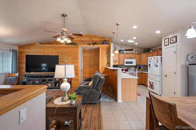 1176 E Purcell Ln, Pueblo, CO 81007 - living room featuring vaulted ceiling, wooden walls, ceiling fan, light tile patterned floors, and recessed lighting