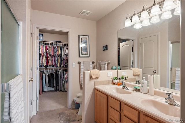 1176 E Purcell Ln, Pueblo, CO 81007 - bathroom featuring toilet, double vanity, tile patterned floors, a spacious closet, and an enclosed shower