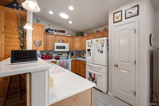1176 E Purcell Ln, Pueblo, CO 81007 - kitchen featuring white appliances, a peninsula, light tile patterned floors, vaulted ceiling, and tasteful backsplash