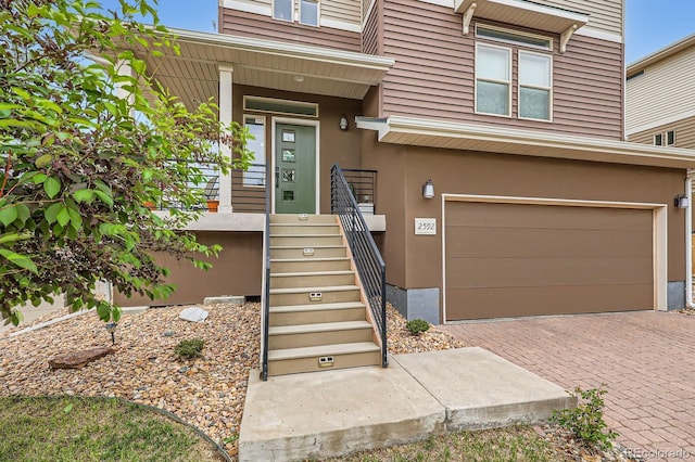 2592 Sweet Wind Ave, Castle Rock, CO 80109 - doorway to property with a garage, decorative driveway, and stucco siding