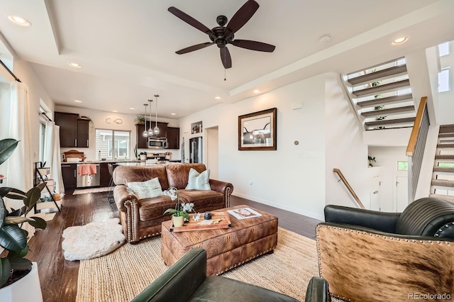 2592 Sweet Wind Ave, Castle Rock, CO 80109 - living area with dark wood-style flooring, stairs, ceiling fan, a tray ceiling, and recessed lighting