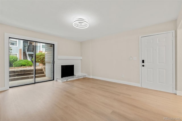 3141 S Tamarac Dr Unit 111G, Denver, CO 80231 - unfurnished living room with light wood finished floors, baseboards, and a fireplace