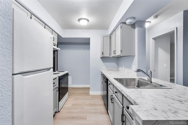 14602 E 2nd Ave Unit 204C, Aurora, CO 80011 - kitchen featuring a sink, a textured ceiling, range with electric cooktop, light countertops, and freestanding refrigerator