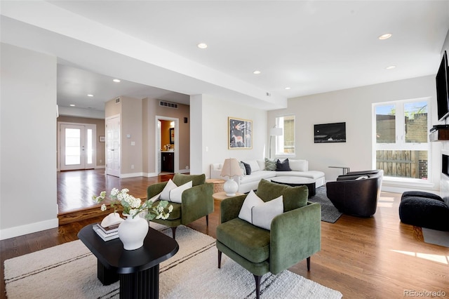living area with wood finished floors, baseboards, recessed lighting, and a fireplace