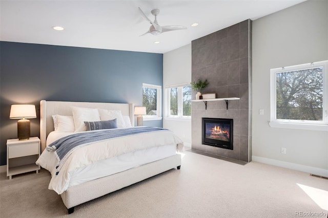 carpeted bedroom with recessed lighting, a tile fireplace, baseboards, and ceiling fan