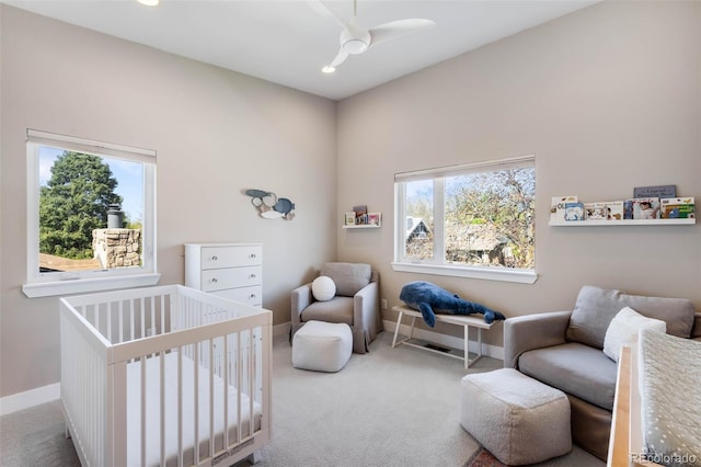 carpeted bedroom featuring a nursery area, multiple windows, baseboards, and recessed lighting