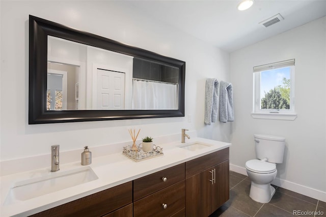 full bathroom with toilet, baseboards, tile patterned floors, and double vanity