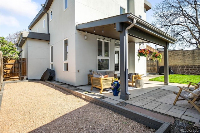 back of house featuring an outdoor living space, fence, and a patio area