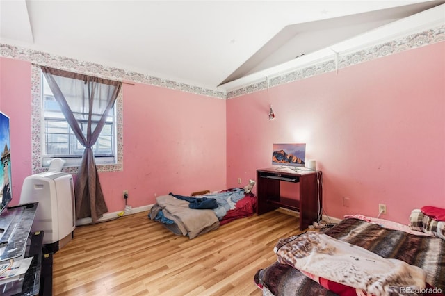 bedroom featuring lofted ceiling and light wood-type flooring