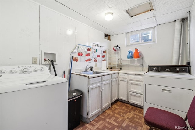 clothes washing area featuring sink, dark parquet floors, and washing machine and clothes dryer