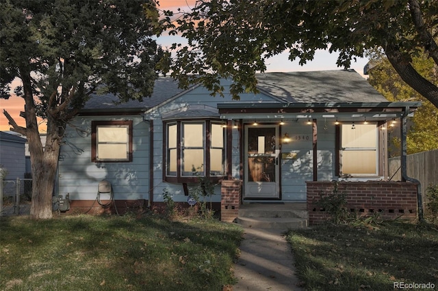 1340 Xanthia St, Denver, CO 80220 - bungalow-style home featuring fence, a shingled roof, and a lawn