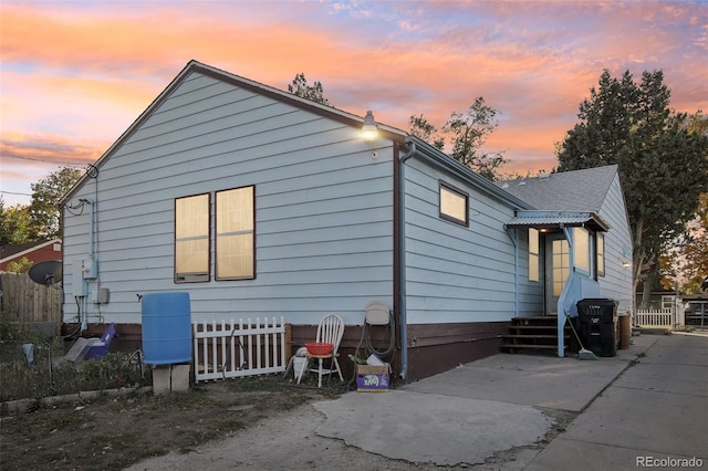 property exterior at dusk with a patio area