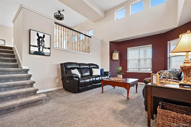 carpeted living area featuring stairway and baseboards