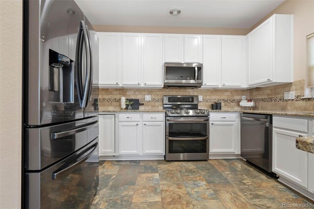 kitchen featuring white cabinetry, light stone countertops, backsplash, and stainless steel appliances