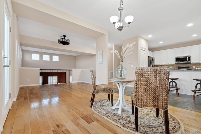 dining space with an inviting chandelier, recessed lighting, baseboards, and light wood-type flooring