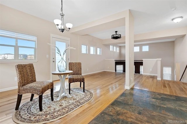 sitting room with an upstairs landing, wood finished floors, baseboards, and a chandelier