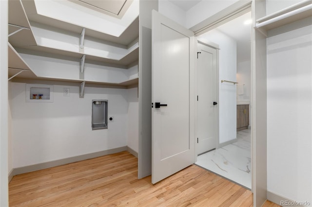 clothes washing area featuring hookup for an electric dryer, washer hookup, and light hardwood / wood-style floors