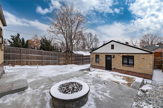 snow covered patio with a fire pit