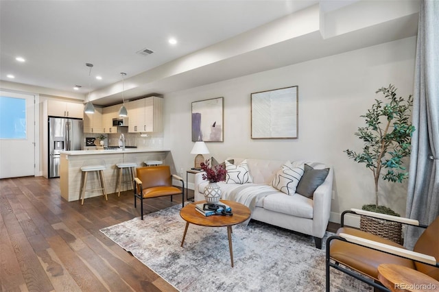 living room featuring dark hardwood / wood-style floors and sink