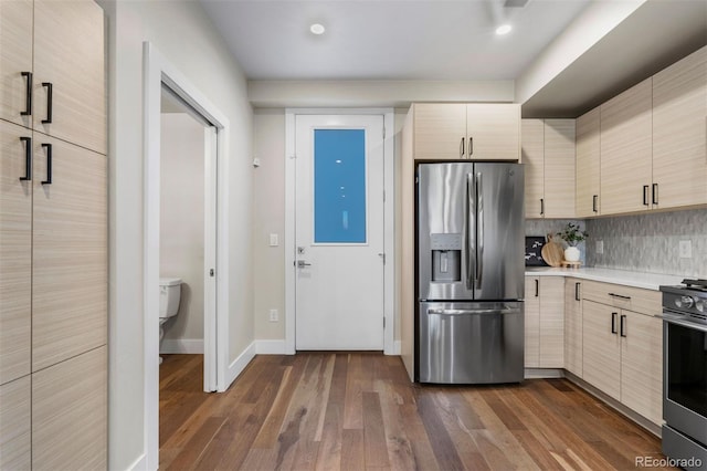 kitchen featuring stainless steel appliances, dark wood-type flooring, and tasteful backsplash