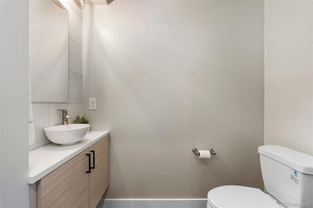 bathroom with backsplash, vanity, and toilet