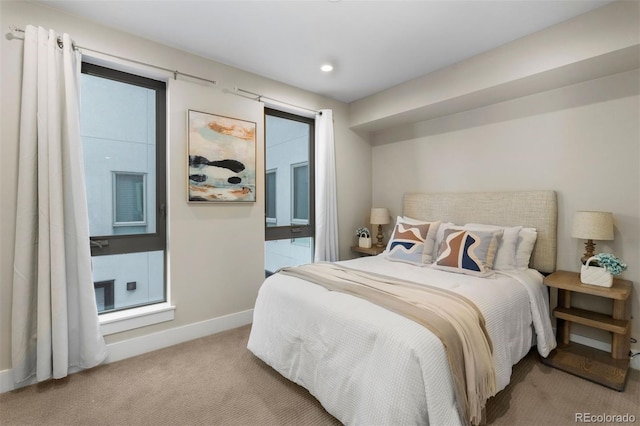 bedroom with light carpet and multiple windows