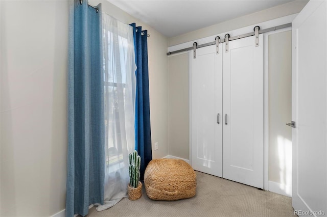 carpeted bedroom with a closet, a barn door, and multiple windows