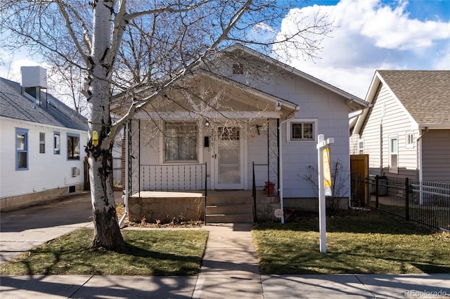 view of front of home with covered porch, driveway, a front yard, and fence