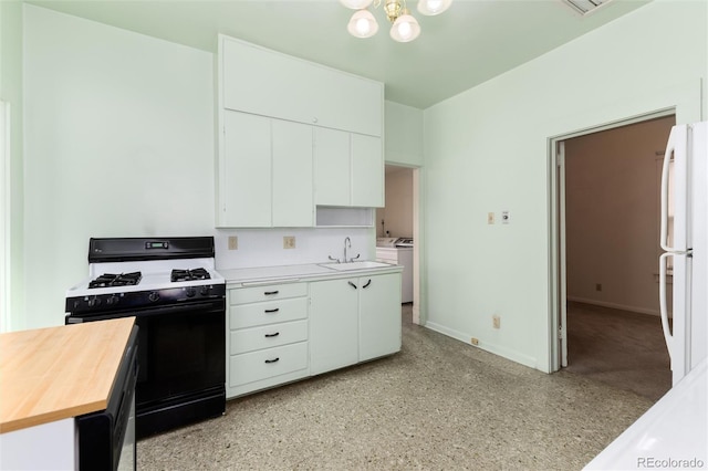 kitchen featuring range with gas stovetop, washer and clothes dryer, butcher block counters, freestanding refrigerator, and a sink