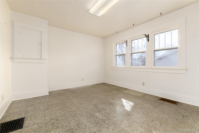 spare room with baseboards and visible vents