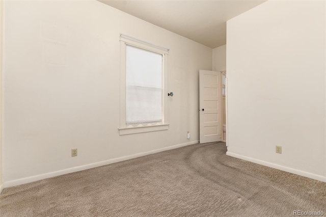 unfurnished room featuring carpet floors and baseboards