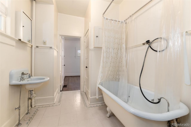 full bath featuring baseboards, shower / bath combo with shower curtain, and tile patterned floors