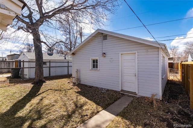 exterior space with an outbuilding, a fenced backyard, and a lawn