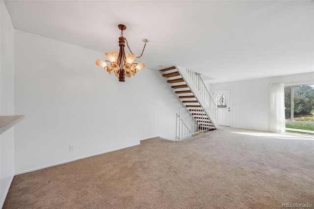 unfurnished living room with baseboards, carpet floors, stairs, and a notable chandelier