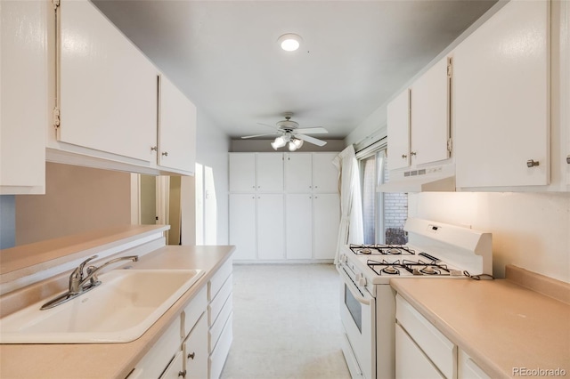 kitchen featuring a sink, white range with gas cooktop, ceiling fan, light countertops, and under cabinet range hood