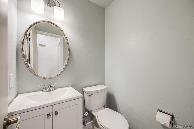 half bathroom featuring toilet and vanity