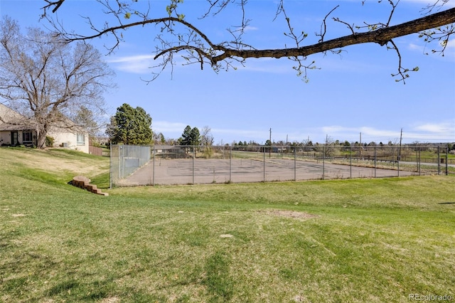 view of yard featuring fence and a tennis court