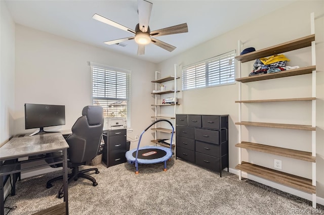 carpeted office space featuring ceiling fan and plenty of natural light