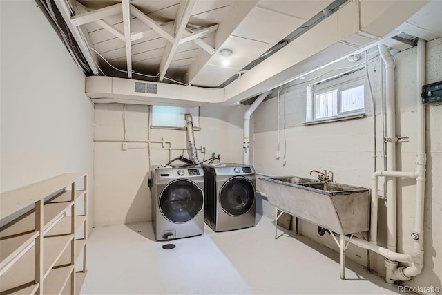 clothes washing area featuring independent washer and dryer and sink