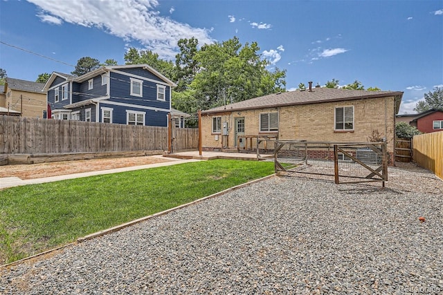 back of property with a lawn and a patio