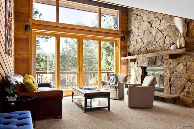 living room featuring carpet flooring, a high ceiling, and wooden walls