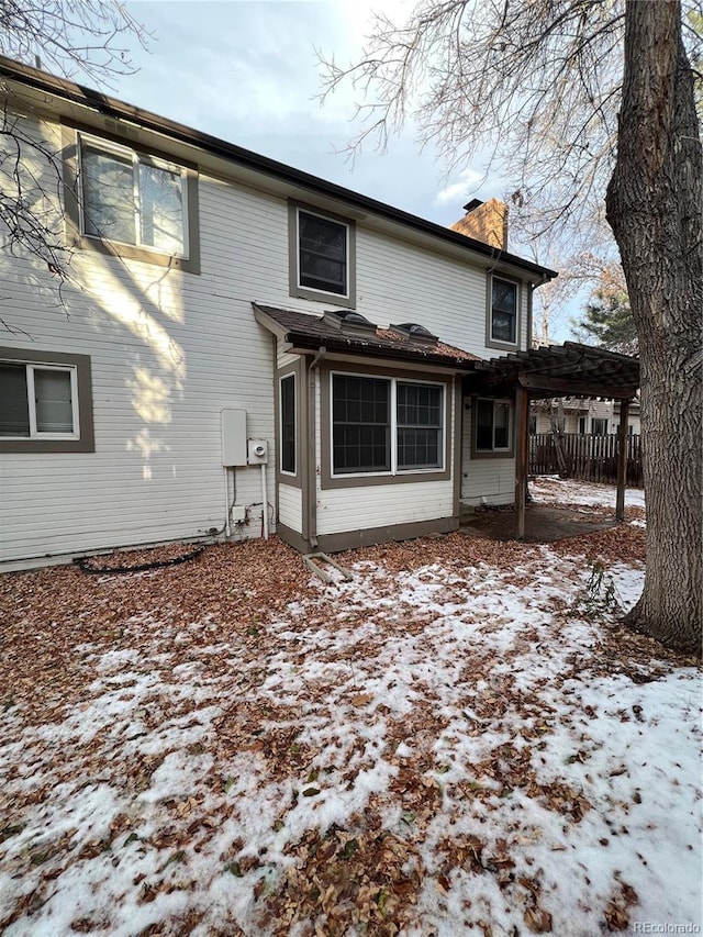 view of snow covered back of property