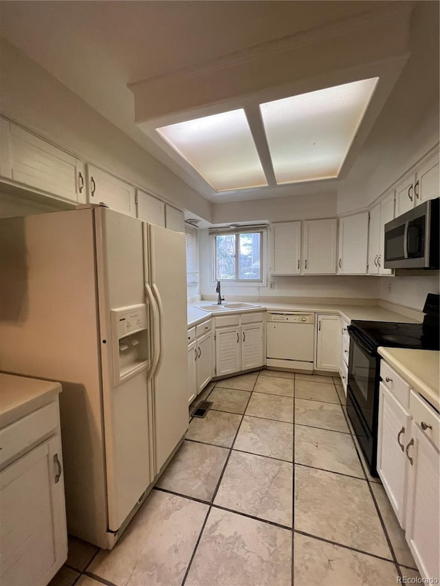 kitchen featuring white cabinets, white appliances, light tile patterned flooring, and sink