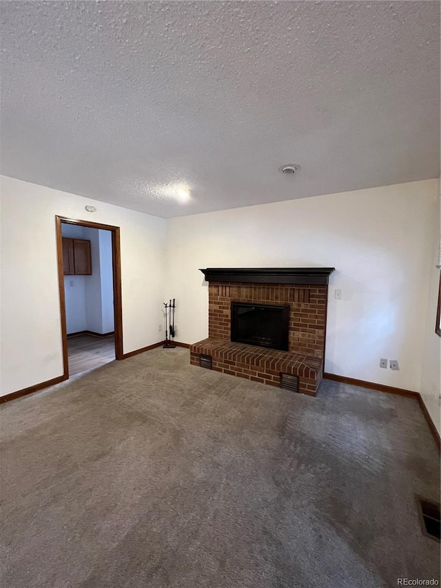 unfurnished living room with a fireplace, carpet floors, and a textured ceiling