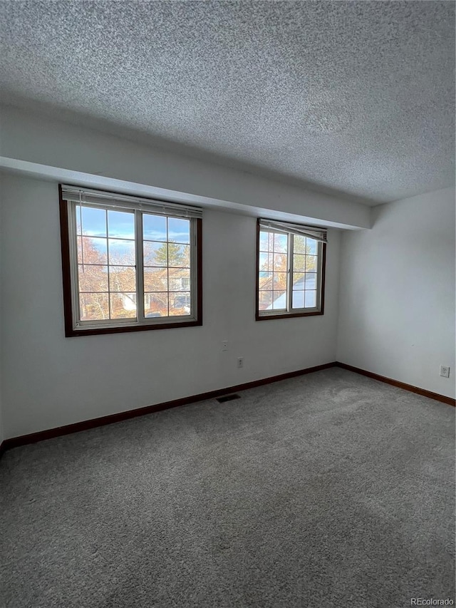 carpeted spare room with a textured ceiling