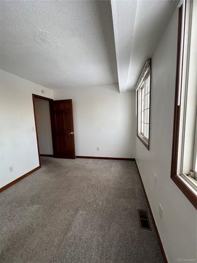 spare room with carpet floors and a textured ceiling