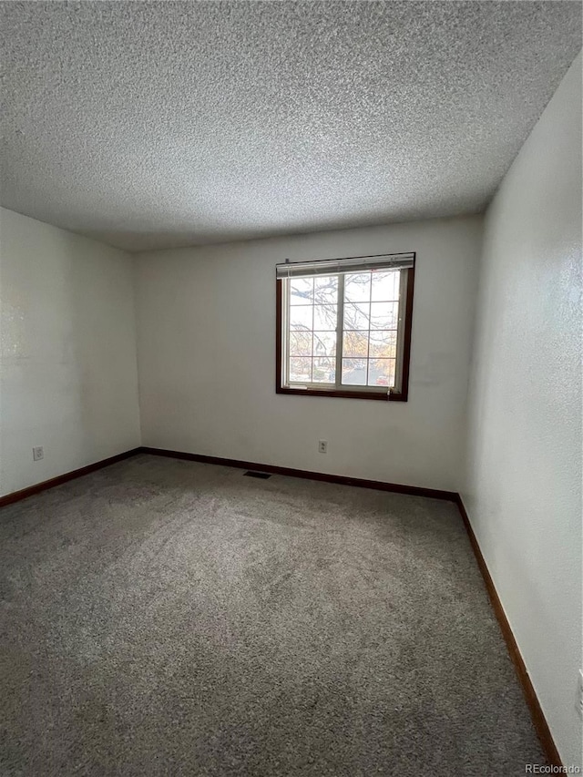 carpeted spare room featuring a textured ceiling