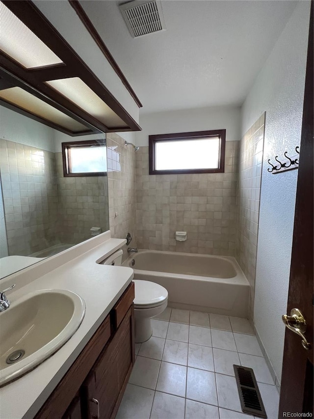 full bathroom featuring tile patterned flooring, vanity, toilet, and tiled shower / bath