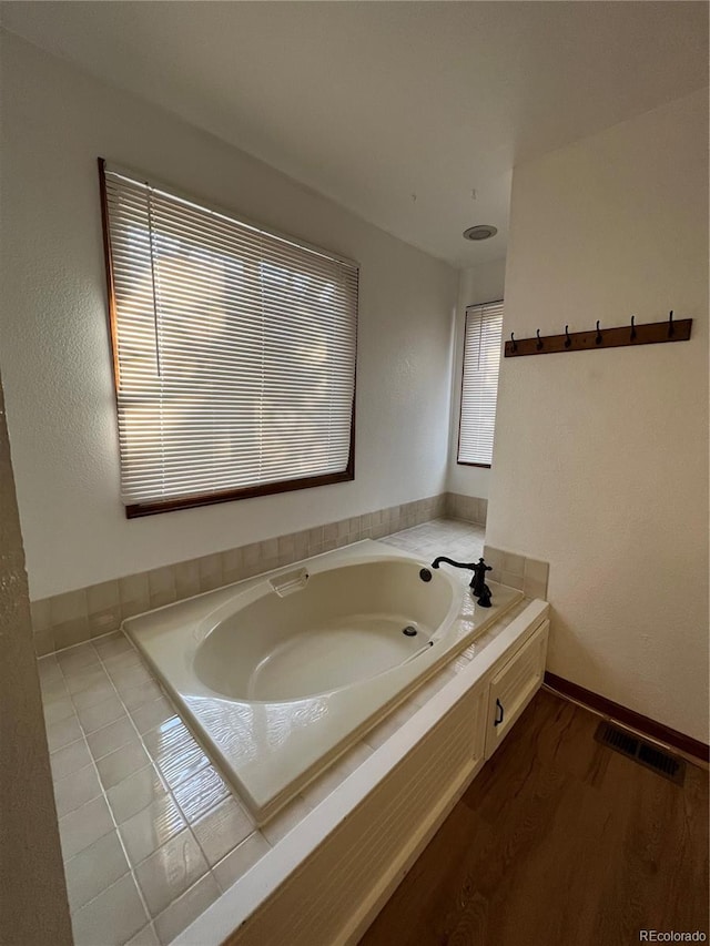 bathroom with hardwood / wood-style floors and a bath