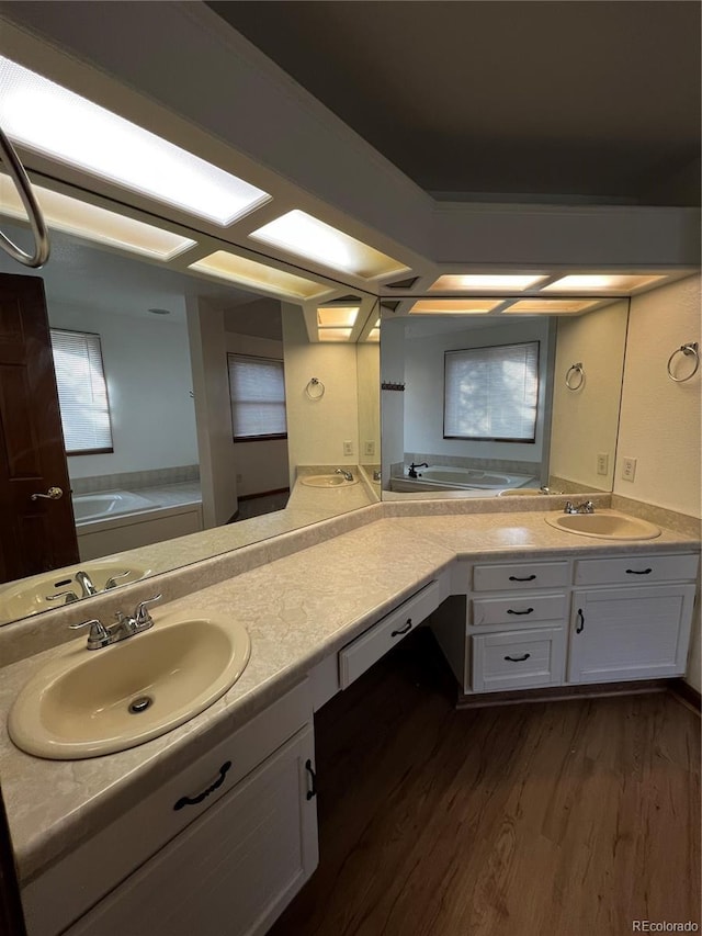 bathroom featuring vanity, wood-type flooring, and a tub to relax in